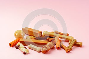 Dog chew bone and sticks on pink background