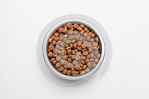 Dog food in a silver bowl. In the center. White background. Copy, text sapce