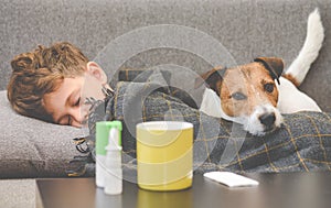 Dog guarding sick boy sleeping on sofa under plaid