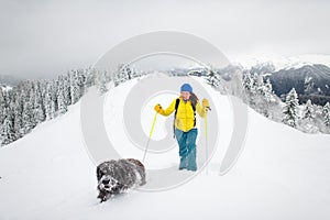 A dog and his mistress alone in the mountains with lots of snow