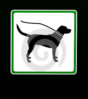 Dog on leash in this area. Restriction sign with copy space.