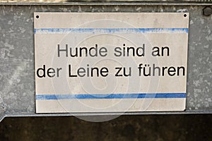 Dog on leash sign in german