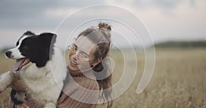 Dog lover stylish girl wearing sunglasses hugging her doggy during they walk. Concept of friendship and hipster