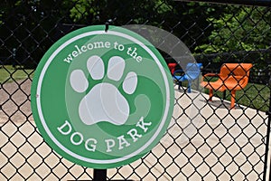 Dog park sign on a chain link fence outside dog park