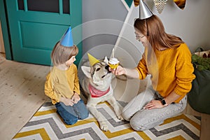 Dog pet birthday party, Happy family mother and child congratulating pet with birthday cupcake happy birthday