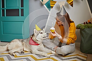 Dog pet birthday party, woman congratulating her pet with birthday cupcake happy birthday