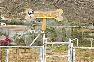 Dog playground near the mountain. The inscription in Spanish - `Dog zone.` Entrance.