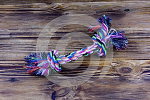 Dog rope toy with tied knots on a wooden background