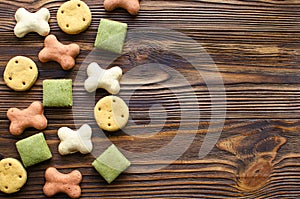 Dog tasty colored biscuits on wooden background with copy space