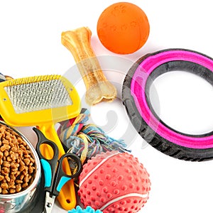 Dog toys, dry food and scissors isolated on white