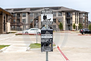 Dog waster station sign with plastic bags for waste. Clean after your dog while walking in