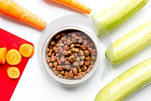 Dogfood, carrot and courgette on table background top view