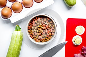 Dogfood, eggs, meat, carrot and courgette on table background to photo