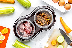 Dogfood set with cut vegetables and knife on table background to