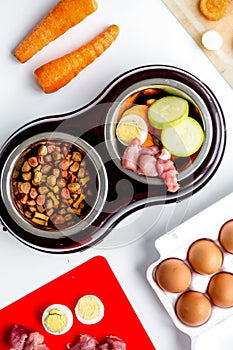 Dogfood set with vegetables, eggs and meat on table background top view