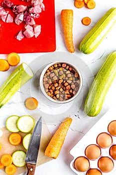 Dogfood set with vegetables, eggs and meat on table background top view photo