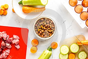 Dogfood set with vegetables, eggs and meat on table background top view