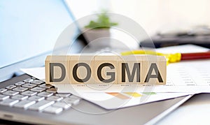 DOGMA Wooden cubes with letters on a laptop keyboard