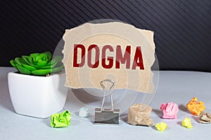 Dogma word on card index paper, on torn paper