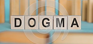 Dogma word written on wooden cubes on background