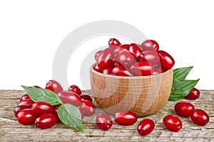 Dogwood berry with leaf in bowl on wooden table with white background