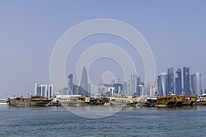 Qatar, Doha, View of the skyscrapers of Doha with traditional arabian dhow photo
