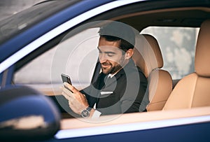 Doing business while on the move. a handsome young businessman sending a text message while on his morning commute to