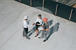 Doing handshake. Top view of men and woman that are on construction site, working together on the project