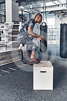 Doing his best. Handsome young African man in sport clothing jumping while exercising in the gym