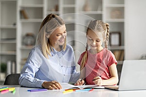 Doing Homework Together. Loving Young Mother Helping Her Little Daughter With Study