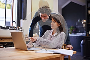 Doing life together. a young couple doing their finances at home.