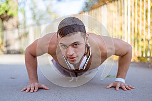 Doing push-ups pushups exercising sports training fitness workout young latin man