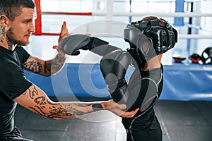 Doing some punches. Coach is teaching the boy box techniques indoors