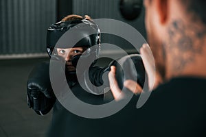 Doing some punches. Coach is teaching the boy box techniques indoors