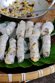 Doing Vietnamese vegetarian dish, make deep fried corn  spring roll, vegan food in leaf background