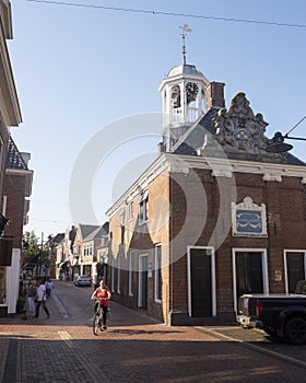 Woman on bicycle next to waag building in old frisian town of dokkum