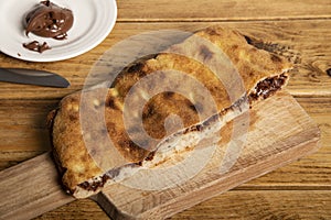 Dolce pizza para niÃÂ±os de nutella sobre tabla de cortar de madera. pizza calzone photo