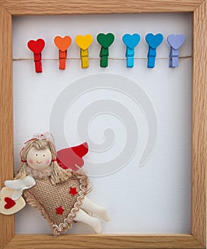 Doll angel and wooden pins in shape of hearts