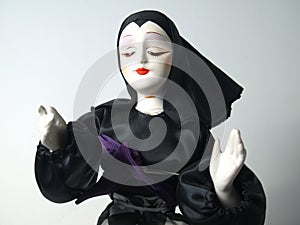 Doll in black habit giving blessing