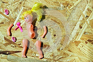 Doll body parts on a wooden background. Copy space. Top view