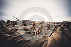 A doll on the bottom of a dried dam.