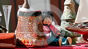 A doll among different things for sale at the flea market.