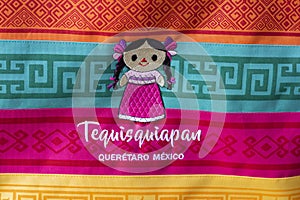A doll emroidered on colorful blanket