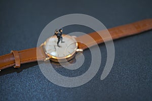 doll figure adult man standing on de-focus hand watch.