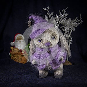 A doll of a hare in purple knitted clothes waiting for Santa Claus