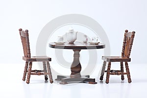 Doll house interior - two chairs and a table served for tea isolated on white background