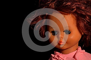 Doll portrait on a black background.