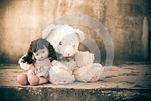 Doll sad with teddy bear