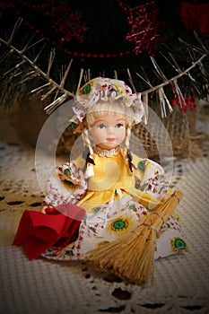 Doll sitting with a broom and dustrag.