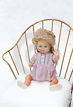 Doll sitting lonesome in an chair